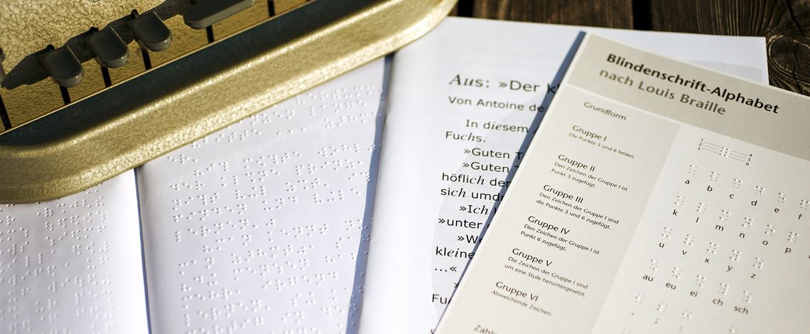 Abbildung einer Kurzgeschichte in Braille und in Schwarzdruck, sowie einem Merkblatt mit dem Brailleschrift-Alphabet.