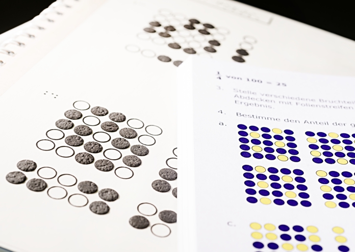 Abbildung einer Seite aus einem Mathematik-Lehrbuch in Braille mit Relief.